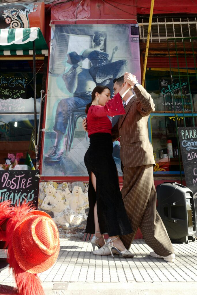 A couple performs an elegant tango dance on a vibrant street in Buenos Aires.